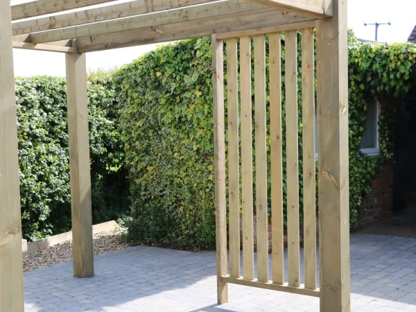 Timber gazebo with sides on a patio in a private garden.