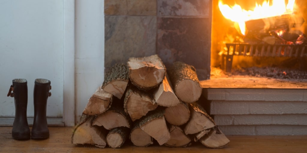 Firewood pile next to a burning fireplace